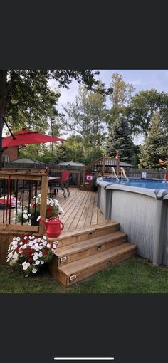 an above ground pool with steps leading up to it and flowers growing on the deck