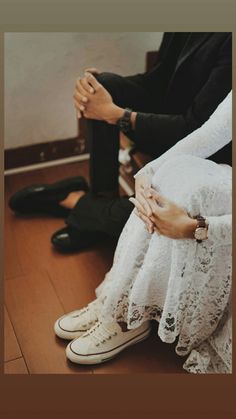 two people are sitting on the floor with their hands clasped over each other's legs