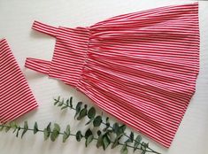 red and white striped paper with green leaves on it next to the cut out pieces