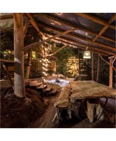 a wooden table sitting under a roof covered in lights