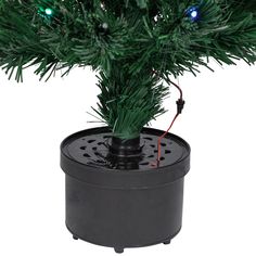 a small christmas tree in a black pot with lights on it's top and bottom