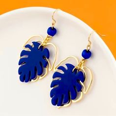 Exotic Hawaiian Monstera Leaf Earrings: Gold & Royal Blue Embrace The Tropical Vibe! Tropical Paradise: These Earrings Beautifully Capture The Essence Of Hawaiian Flora, With A Royal Blue Solid Leaf Layered On Top Of A Golden Outlined Leaf. Double-Layered Beauty: The Two Layers Add Depth And Dimension To These Earrings, Making Them Truly Eye-Catching. Size: These Earrings Are The Ideal Size To Make A Statement Without Being Too Overwhelming. Smoke Free & Loving Home Packaged With Care Leaf Earrings Gold, Monstera Leaf Earrings, Tropical Earrings, Earrings Making, Golden Leaves, Hawaiian Style, Blue Solid, Tropical Vibes, Monstera Leaf