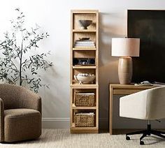 a living room with a chair, desk and bookshelf next to a plant