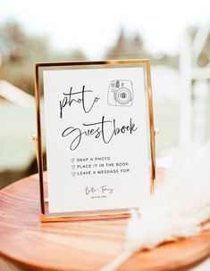 a sign that is sitting on top of a wooden table with a feather in front of it