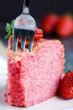 a fork stuck into a slice of strawberry cake