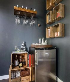 a refrigerator freezer sitting inside of a kitchen next to a wooden shelf filled with wine glasses