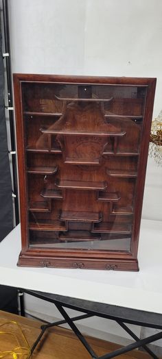 an old wooden bookcase sitting on top of a table