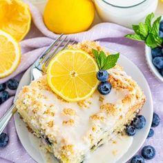 a slice of lemon blueberry coffee cake on a white plate with fresh fruit around it