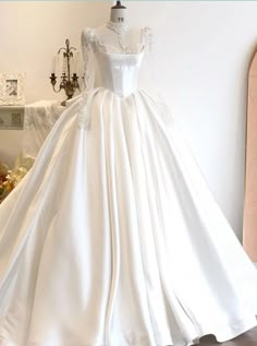 a white wedding dress on display in a room