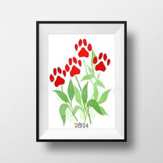 a red flower with green leaves in a black frame