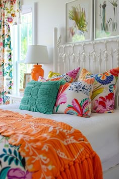 a white bed topped with lots of colorful pillows