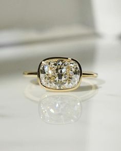 a yellow and white diamond ring sitting on top of a table