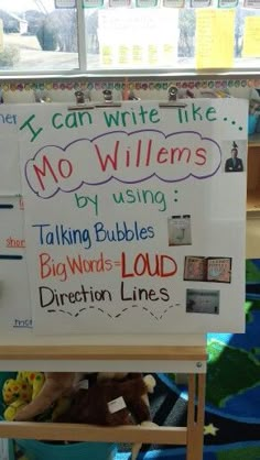 a white board with writing on it in front of a classroom desk filled with children's books