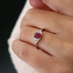 a woman's hand with a diamond and ruby ring