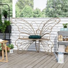 a bench sitting on top of a wooden deck next to a planter filled with potted plants