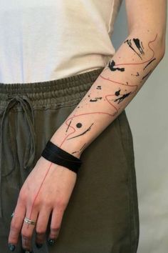 a woman's arm with an abstract tattoo on the left side of her arm