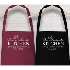 two personalized aprons hanging on a wall with the words kitchen and serving by hand