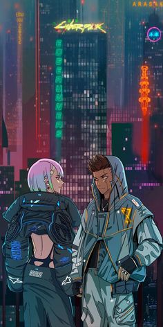 two people standing next to each other in front of a cityscape at night