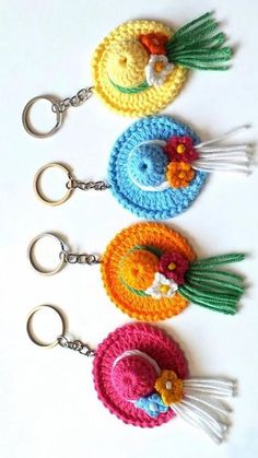 four crocheted keychains with tassels and flowers on each one