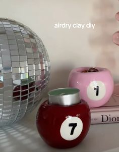 two vases sitting on top of a table next to a book and disco ball