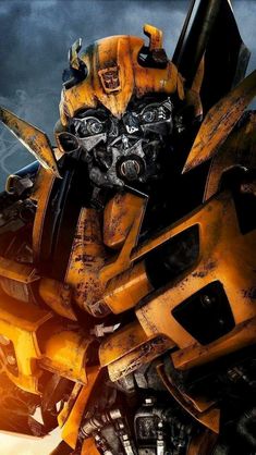 a yellow and black transformer robot standing in front of a dark sky with clouds