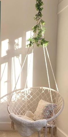 a white hanging chair with plants in it