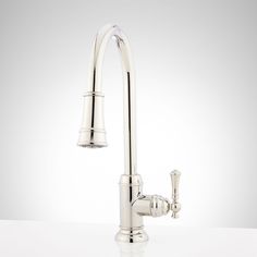 a kitchen faucet that is on top of a white countertop, with the water running from it's spout