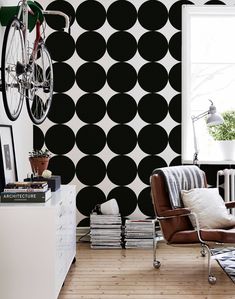 a living room with black and white polka dot wallpaper, a bike hanging on the wall