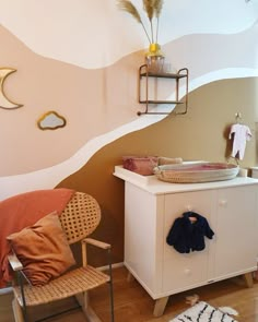 a baby's room with a crib, chair and wall mural on the walls