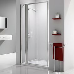 a bathroom with a stand up shower next to a white sink and red towel rack