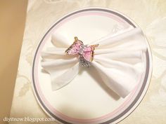 a white plate topped with a pink and gold bow