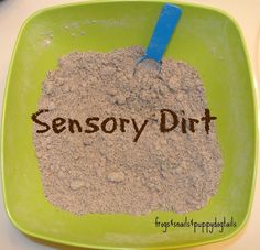 a green bowl filled with dirt and the word sensory dirt written in brown on it