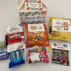 a box filled with candy and snacks on top of a table