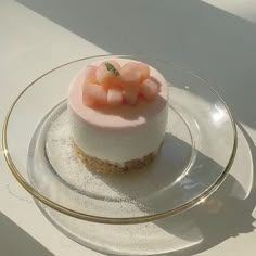 a small dessert on a glass plate with a gold rim and some fruit toppings