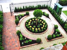 an aerial view of a small garden with trees and shrubs in the center, surrounded by brick walkways