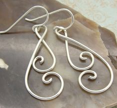 "These double spiral earrings are handmade by my daughter from sturdy sterling silver wire. They are smoothly curved and nicely polished, and are lightweight and comfortable to wear. We get tons of compliments on these. She's taken sterling silver wire and shaped it into a swirly double spiral, hand tempered them, smoothed the rough edges off and tumble polished them to make them springy and shiny. What I like about these is that the spirals touch each other, so your hair doesn't tend to get cau Diy Silver Earrings, Adjustable Spiral Sterling Silver Wrap Earrings, Bell Earring, Aluminum Wire Jewelry, Wire Earrings Handmade, Wire Jewelry Earrings, Silver Wire Earrings, Wire Wrap Jewelry Designs, Wire Wrapped Jewelry Diy