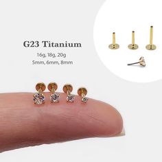 three pairs of diamond studs are shown on the thumb and in front of a hand