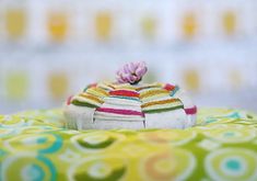 a small toy hat sitting on top of a green and yellow table cloth covered plate