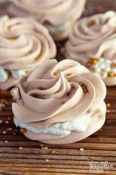 cupcakes with frosting and gold sprinkles on a wooden table