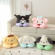 four stuffed animals sitting on top of a white couch