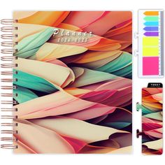 a spiral notebook with an assortment of colorful feathers on the cover, and a notepad next to it