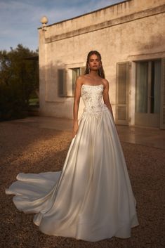 a woman in a wedding dress standing outside