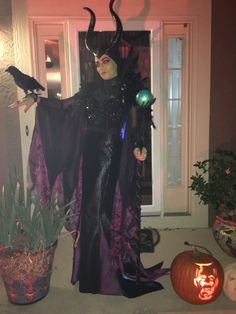 a woman dressed up as maleficent in front of a door