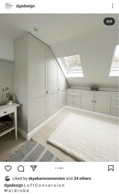 an attic bedroom with white cabinets and carpet on the floor, in front of a window