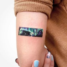 a woman's arm with an aurora bore tattoo on the left side of her arm