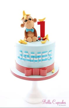 a blue and red cake with a monkey on it's top that says 1