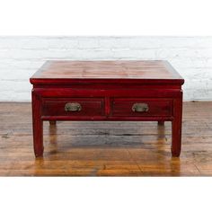 an old red coffee table with two drawers