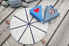 three pieces of cloth sitting on top of a wooden table next to rocks and stones