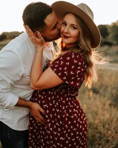 a man and woman kissing in a field