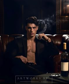 a shirtless man sitting on a leather chair with a bottle of wine in front of him